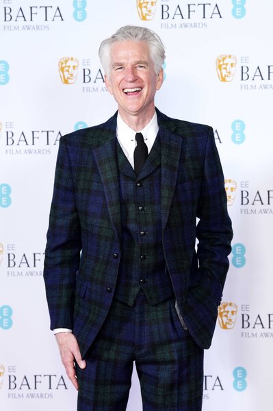 Matthew Modine attends an event wearing a navy and green plaid suit.