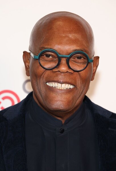 Samuel L. Jackson smiles with black circle glasses.