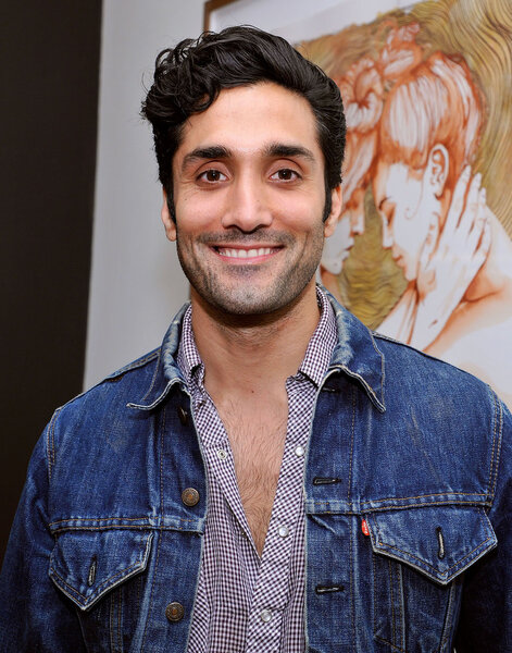 Dominic Rains smiles in a denim jacket.