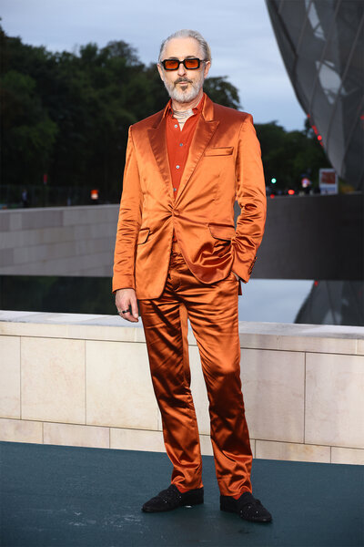 Alan Cumming wears an orange silk suit to the prelude to the paris games