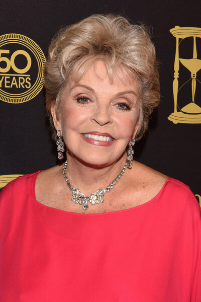 Susan Hayes wears a red top and diamond necklace