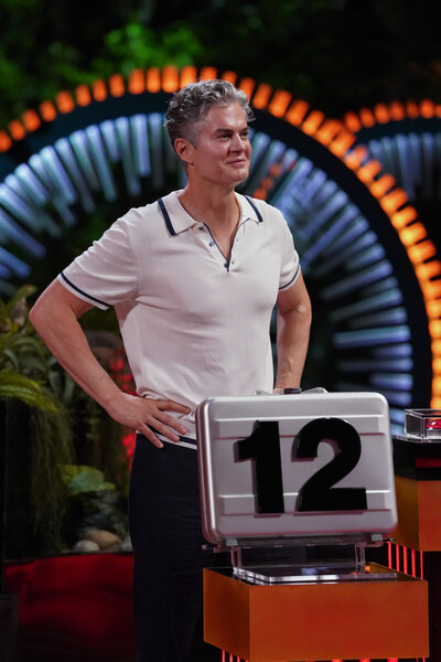 "Dr. Will" Kirby stands behind a #12 briefcase on Deal or No Deal Island Episode 205.