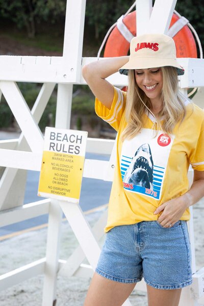 A model wearing a bucket hat with a Jaws t-shirt for Universal Studios Jaws 50th Anniversary.