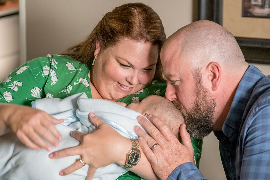 Kate and Toby craddling their baby