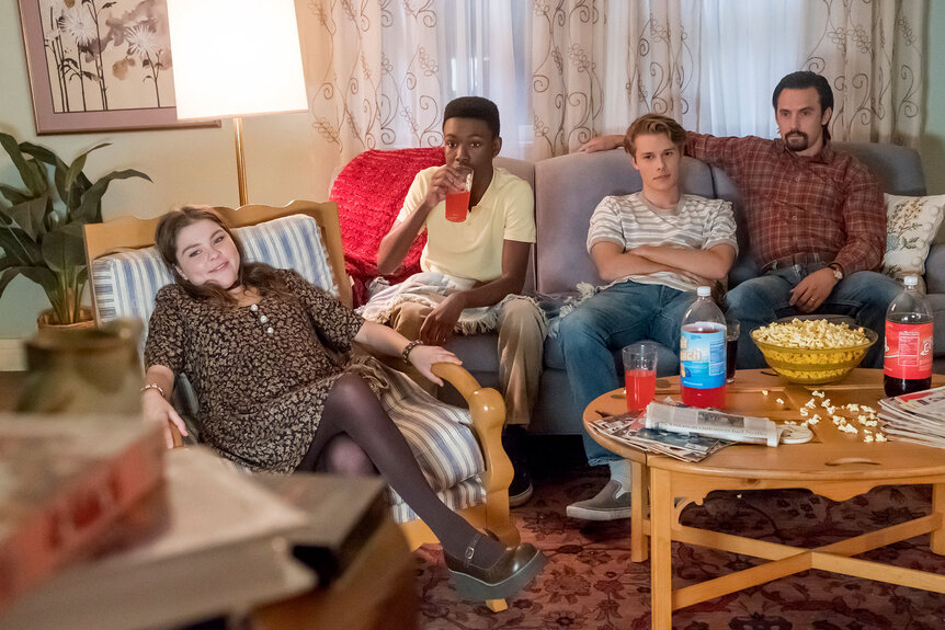 Teen Kate, Randall, Kevin, and Jack watching tv together in their living room