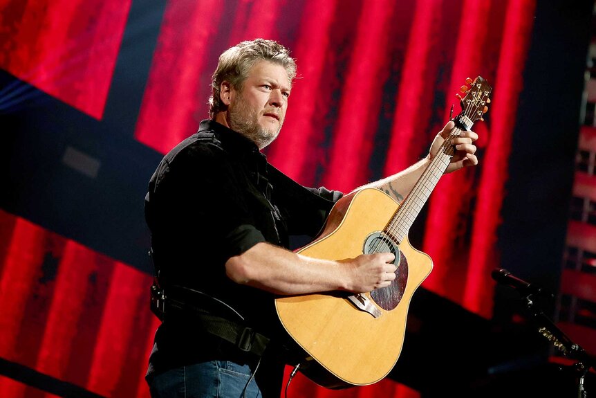 Blake Shelton on stage playing guitar.