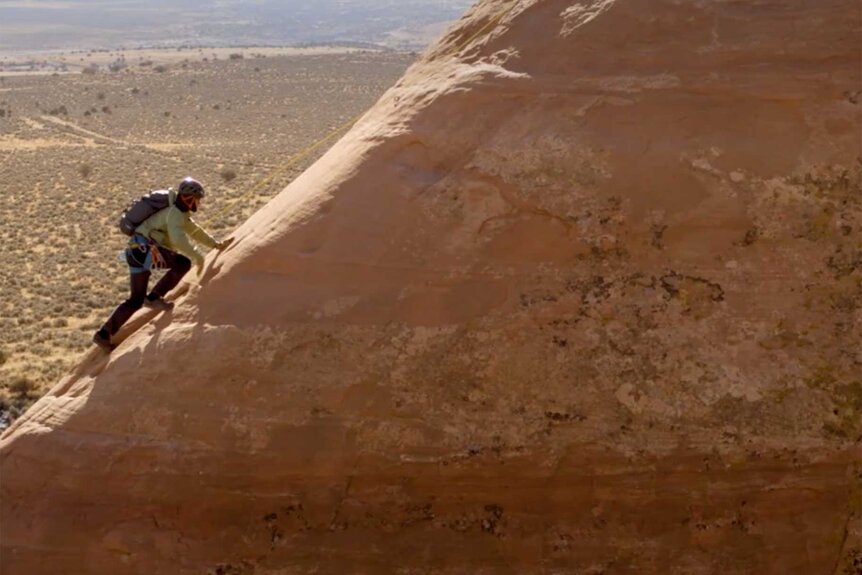 Orlando Bloom climbing a mountain.