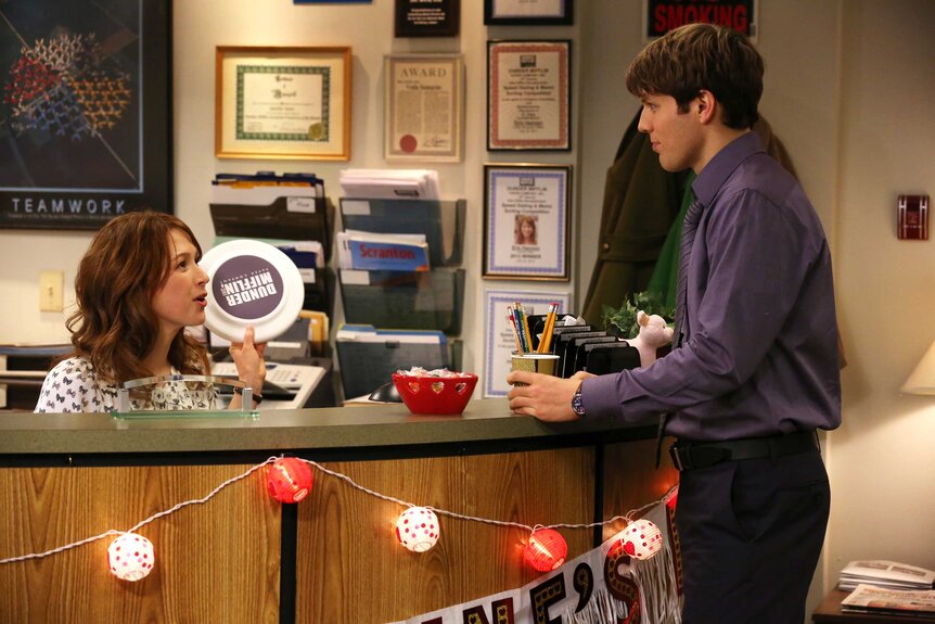 Erin and Pete talking over a desk.