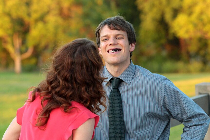 Pete smiling to Erin with gunk in his teeth.