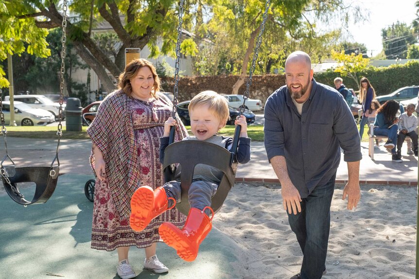 Kate and Toby pushing Baby Jack in a swing.