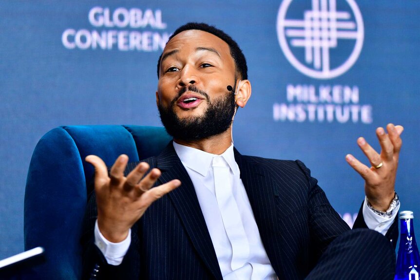 John Legend speaking at an event.