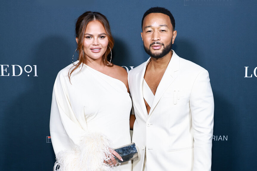 John Legend and Chrissy Teigen pose on a red carpet