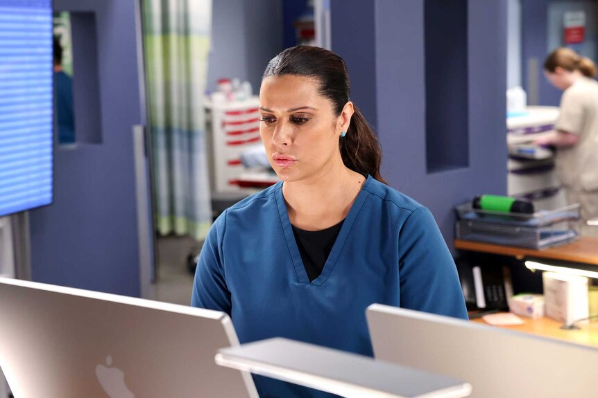 Nurse Doris in a hospital facing a laptop.