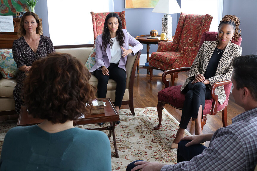 Kelli Williams as Margaret Reed, Gabrielle Elise Walsh as Lacey Quinn, and Shanola Hampton as Gabi Mosely sit in front of a couple