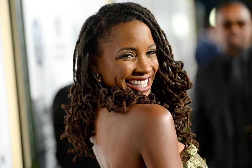 Shanola Hampton smiles and poses on a red carpet