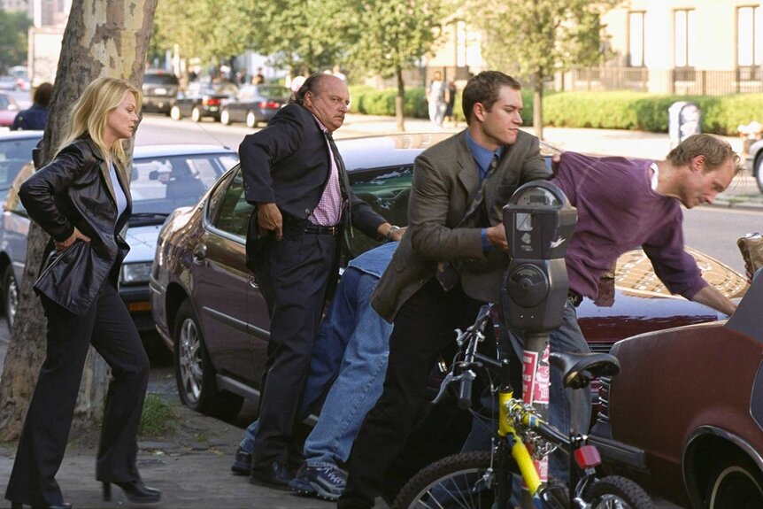 Detectives Connie McDowell, Andy Sipowicz, and John Clark arresting a character during a scene from NYPD Blue.