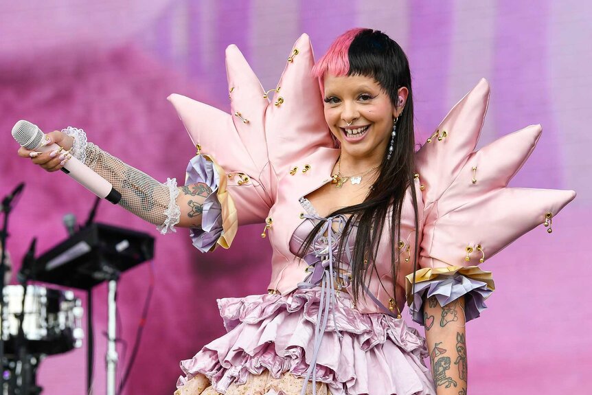 Melanie Martinez holding the microphone out at the Outside Lands Music and Arts Festival.