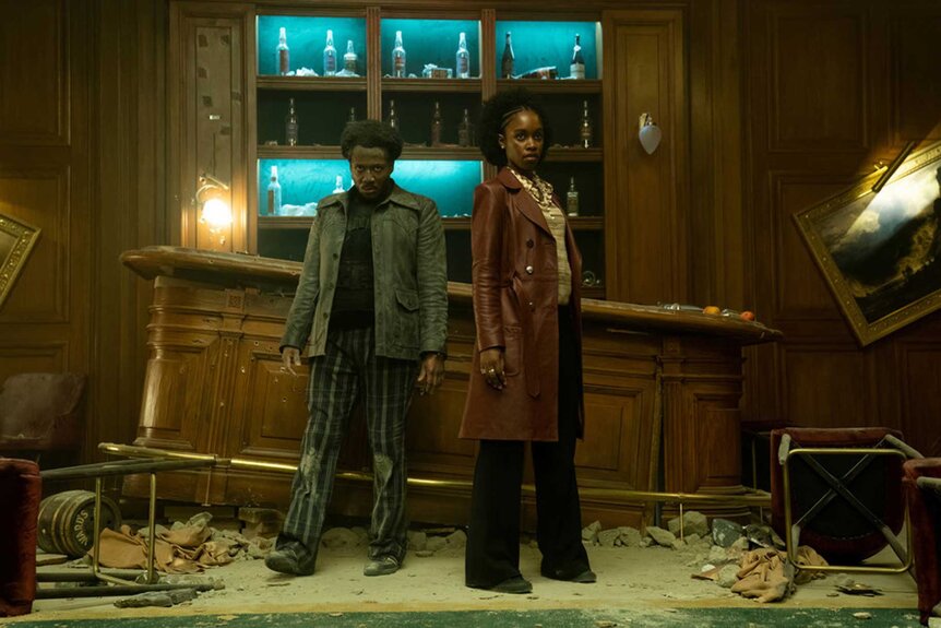 Miles and Lou appear in a room together during a scene from The Continental.