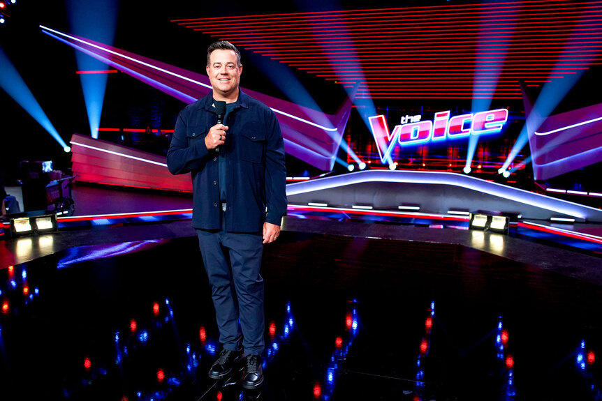 Carson Daly stands on The Voice stage during the premiere episode