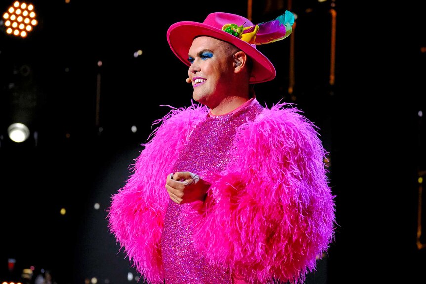 Hans, wearing an all ping outfit and hate, stands on stage during America's Got Talent.