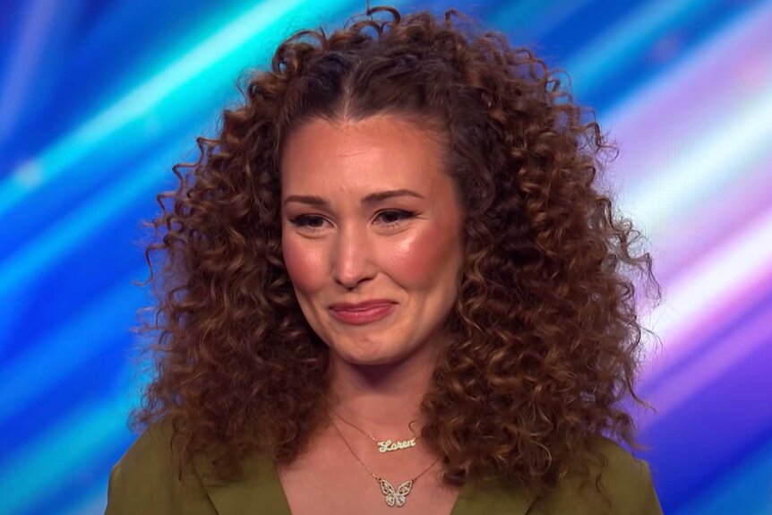 A close up of Loren Allred on stage smiling and looking at the judges.