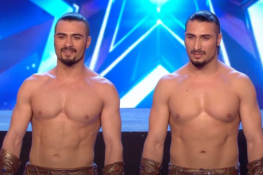 Vardanyan Bros on stage standing next to each other shirtless.