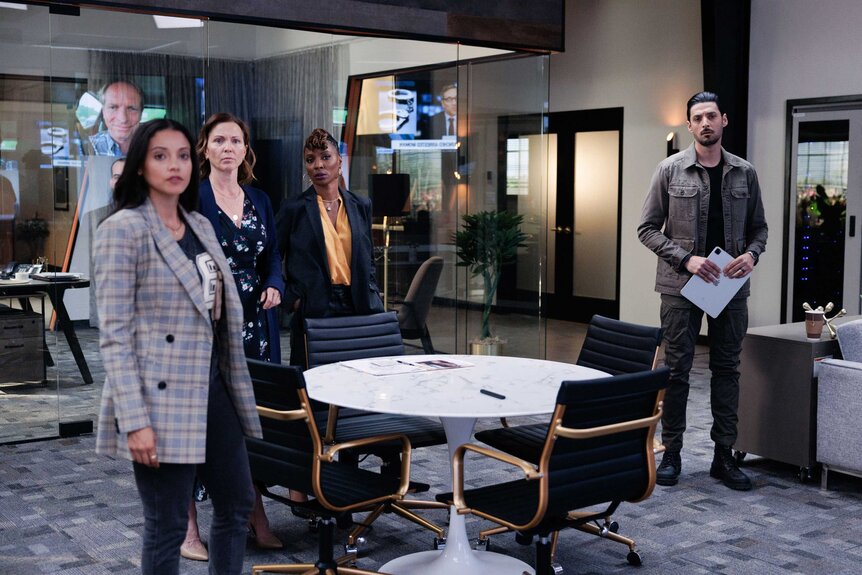 Lacey Quinn, Margaret Reed, Gabi Mosely, and Dahn Rana standing around a table.