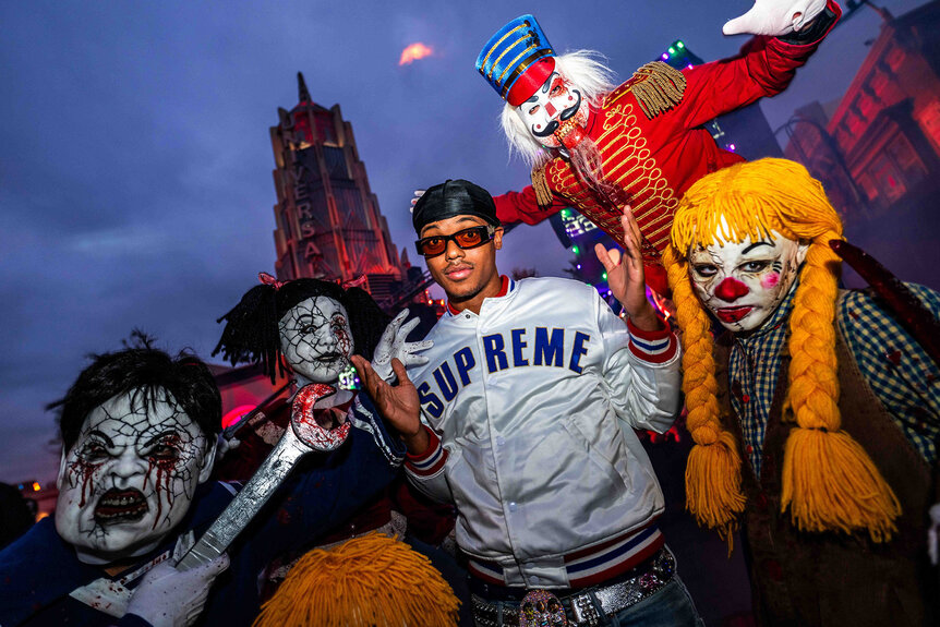 Jabari Banks poses with costumed characters from Halloween Horror Nights