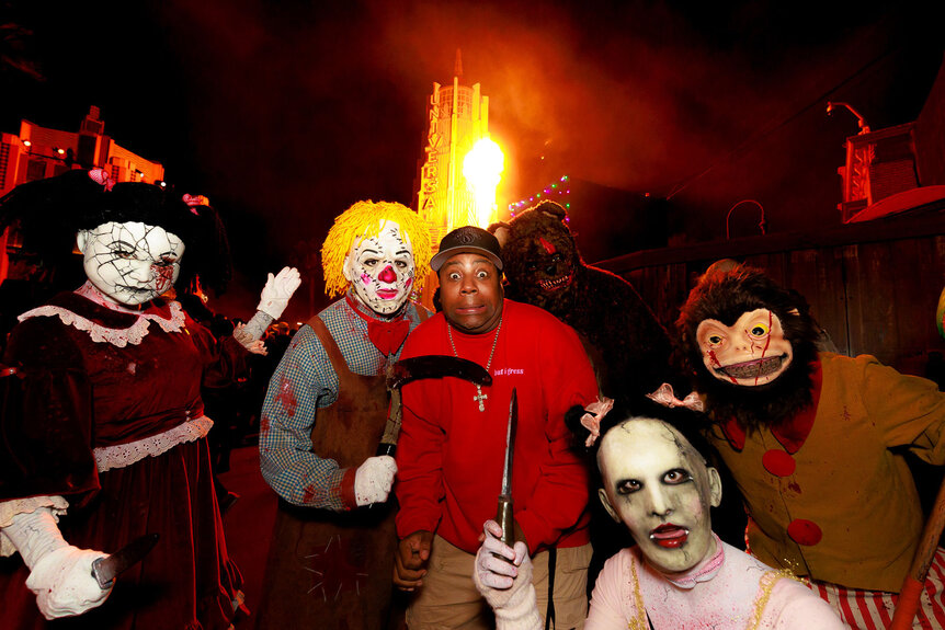 Keenan Thompson poses with costumed characters from Halloween Horror Nights