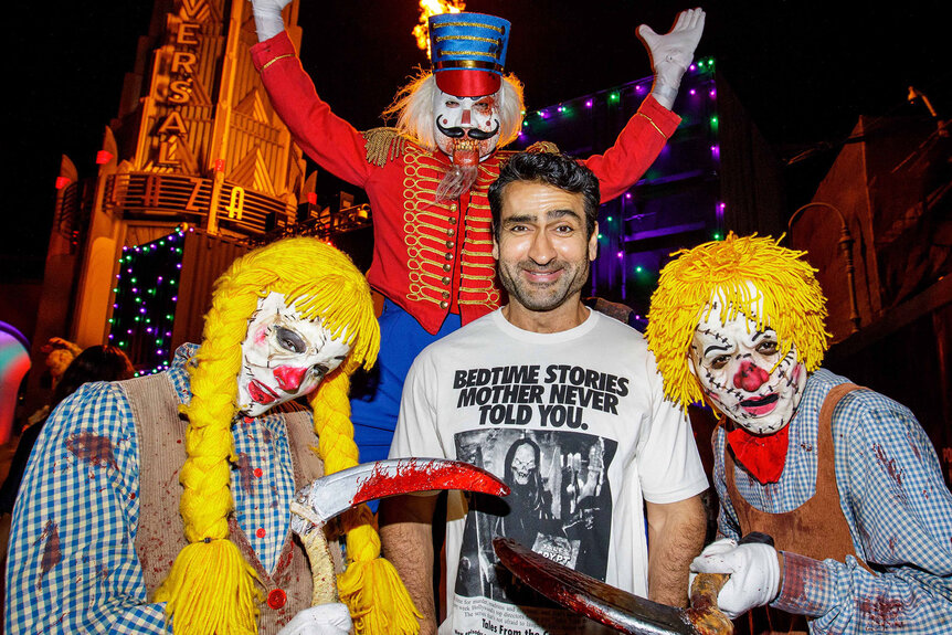 Kumail Nanjiani poses with costumed characters from Halloween Horror Nights