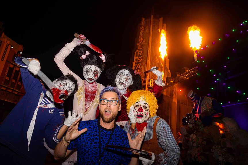 Lance Bass poses with costumed characters from Halloween Horror Nights