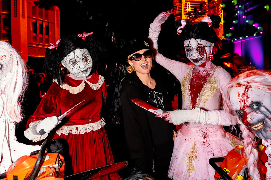 Paris Hilton poses with costumed characters from Halloween Horror Nights