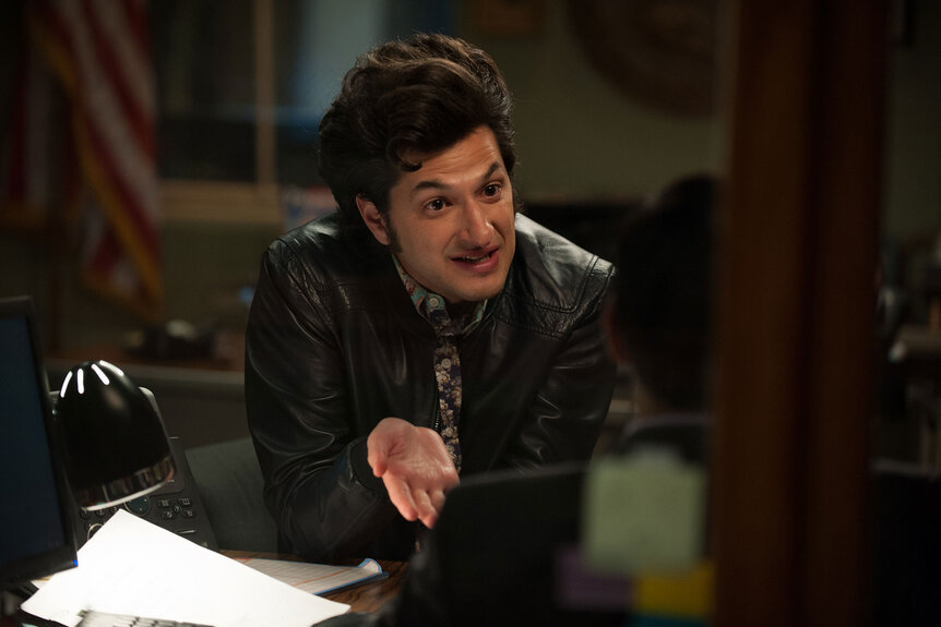 Ben Schwartz as Jean-Ralphio Saperstein leans across a table