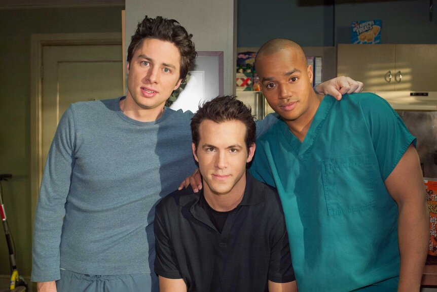 Dr. John Dorian, Spence, and Dr. Christopher Turk posing together on the set of Scrubs.