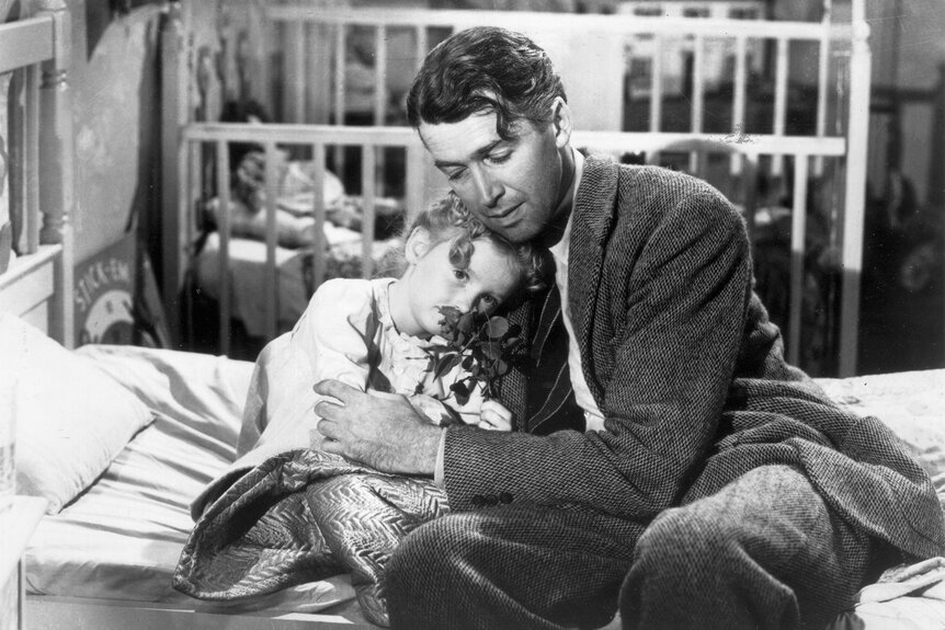 James Stewart as George Bailey, hugs actor Karolyn Grimes