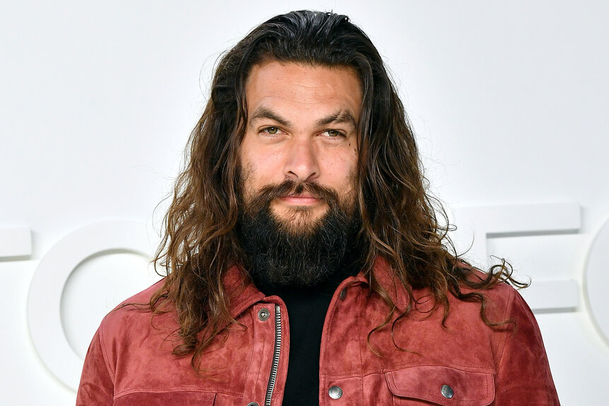 Jason Momoa smiles while at a fashion show