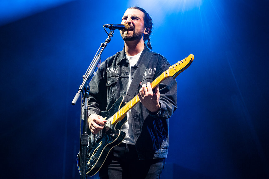 Noah Kahn performs on stage at a music festival