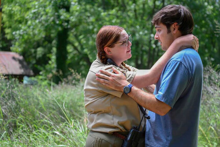 Lisa and John together with their arms around each other in the middle of grassy land.