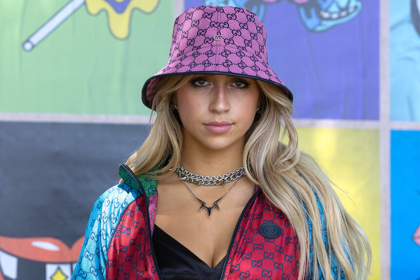 Tate McRae backstage at Lollapalooza wearing a purple bucket hat