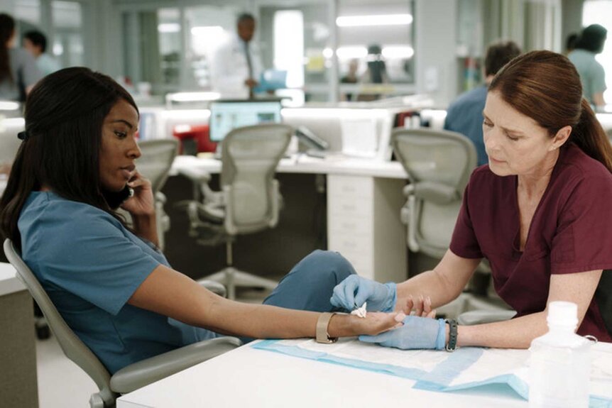 Dr. June Curtis sitting across from Claire Malone who is touching her hand.