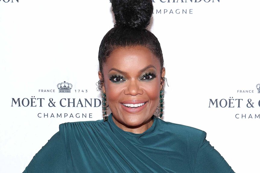 Yvette Nicole Brown smiles in a teal dress.