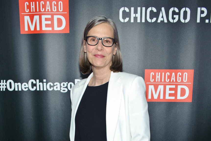 Amy Morton smiles in a white blazer and black top.