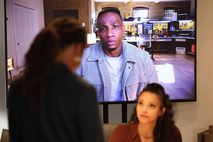 Zeke Wallace appears on a TV screen behind Lacey Quinn in Found Episode 113.