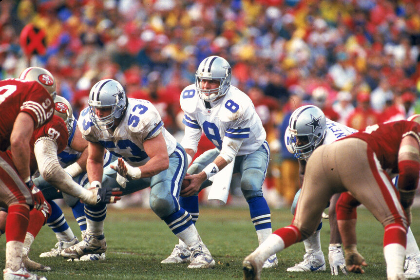 Quarterback Troy Aikman of the Dallas Cowboys #8 takes the snap from center Mark Stepnoski #53 against the San Francisco 49ers