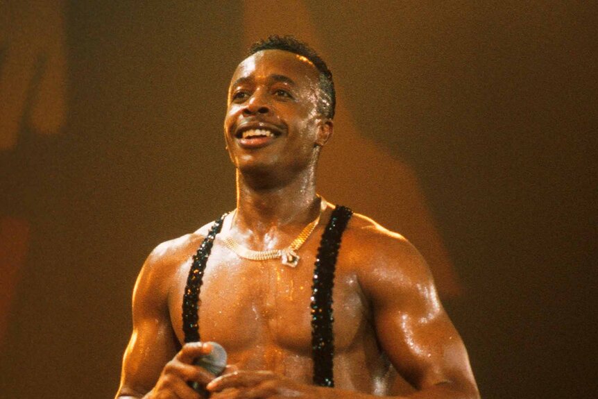 MC Hammer smiles shirtlesss onstage.