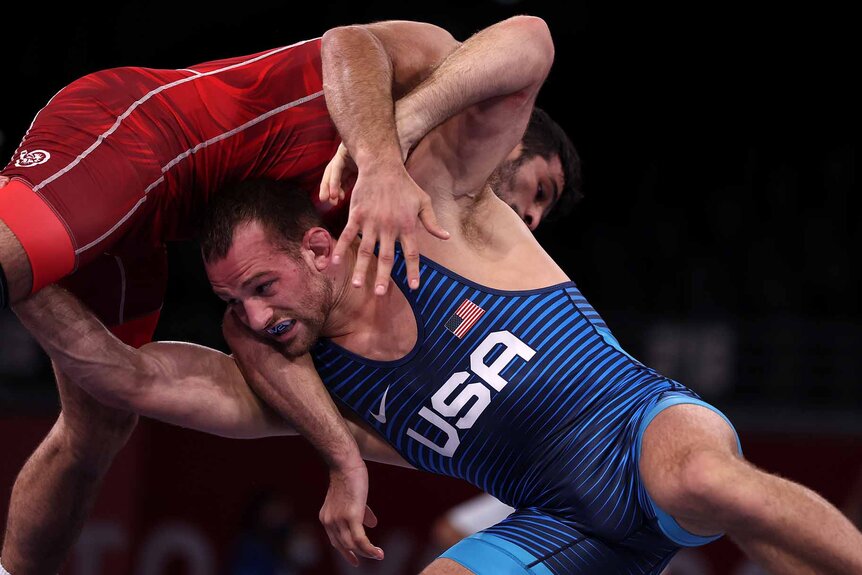 David Morris Taylor III, wearing blue, wrestles Hassan Yazdanicharati.