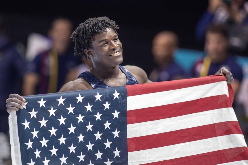 Frederick Richard holds up an American flag.