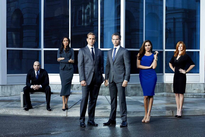 The cast of Suits Season 2 pose in front of a building.