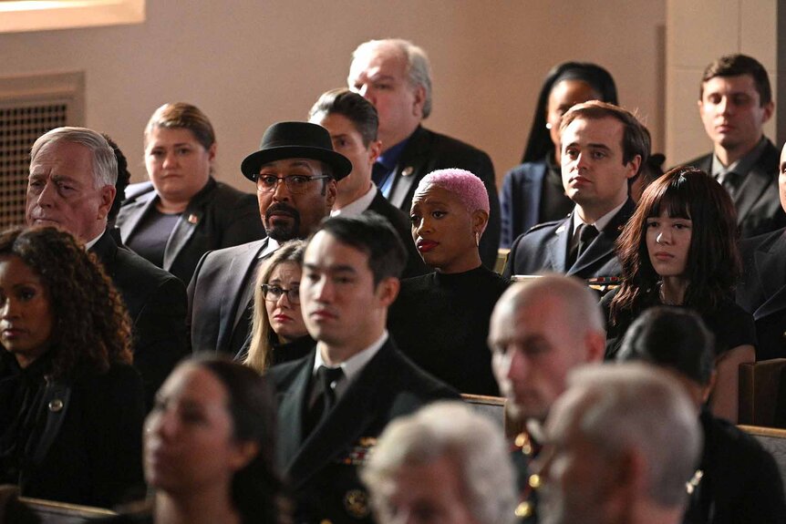 Alec Mercer and Kylie sit amongst funeral attendees in The Irrational Episode 111.