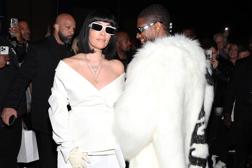 Jennifer Goicoechea and Usher wear all white and sunglasses while posing for a photo together